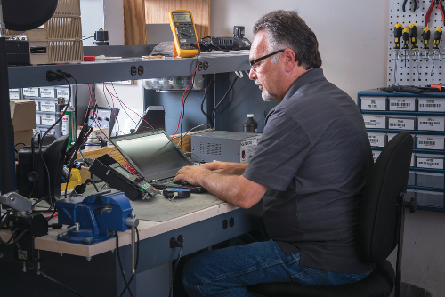 An image of Doug Winchester working on a computer at a desk.